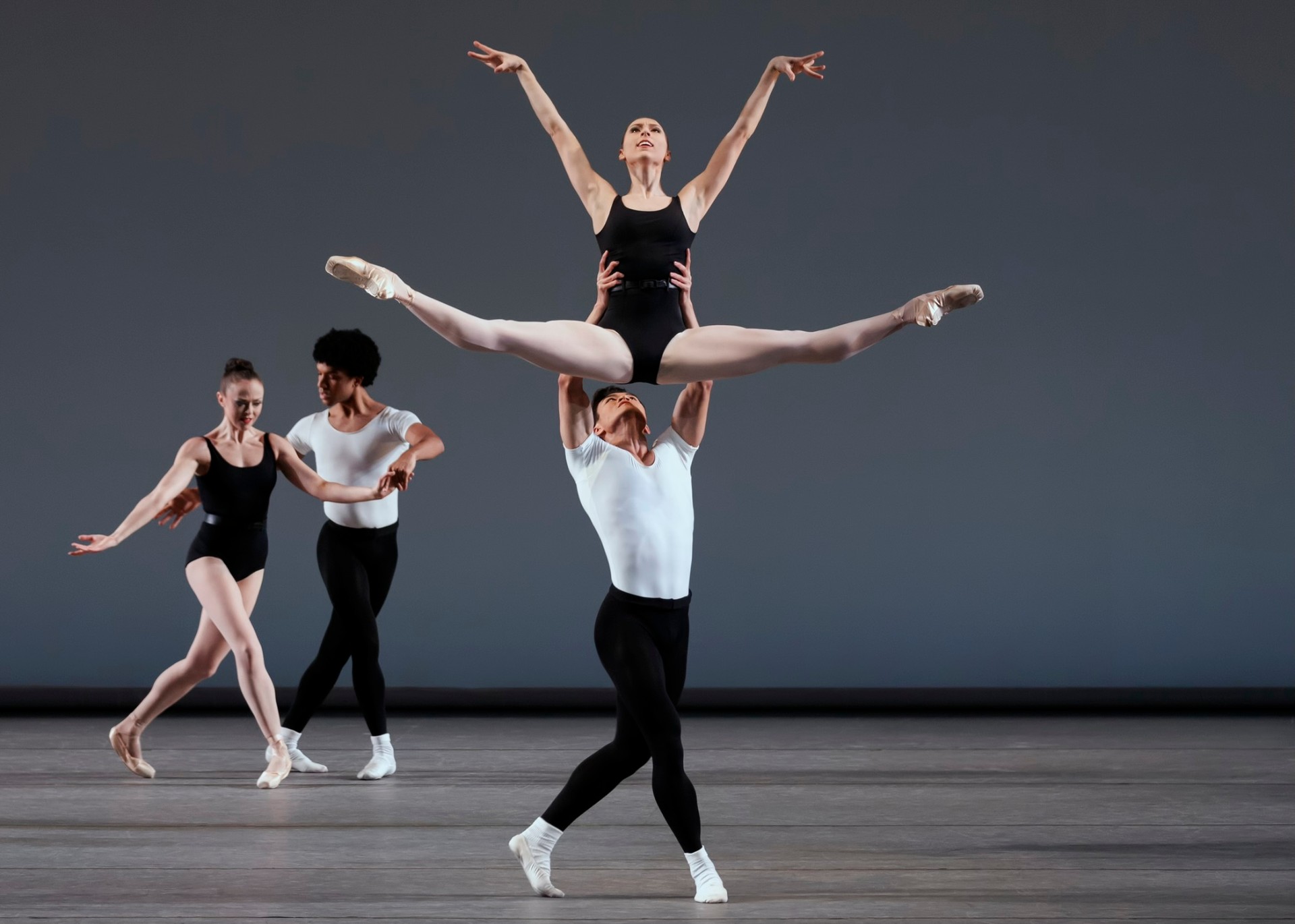 Episodes series — Episodes — overhead split lift in black and white leotards against grey backdrop