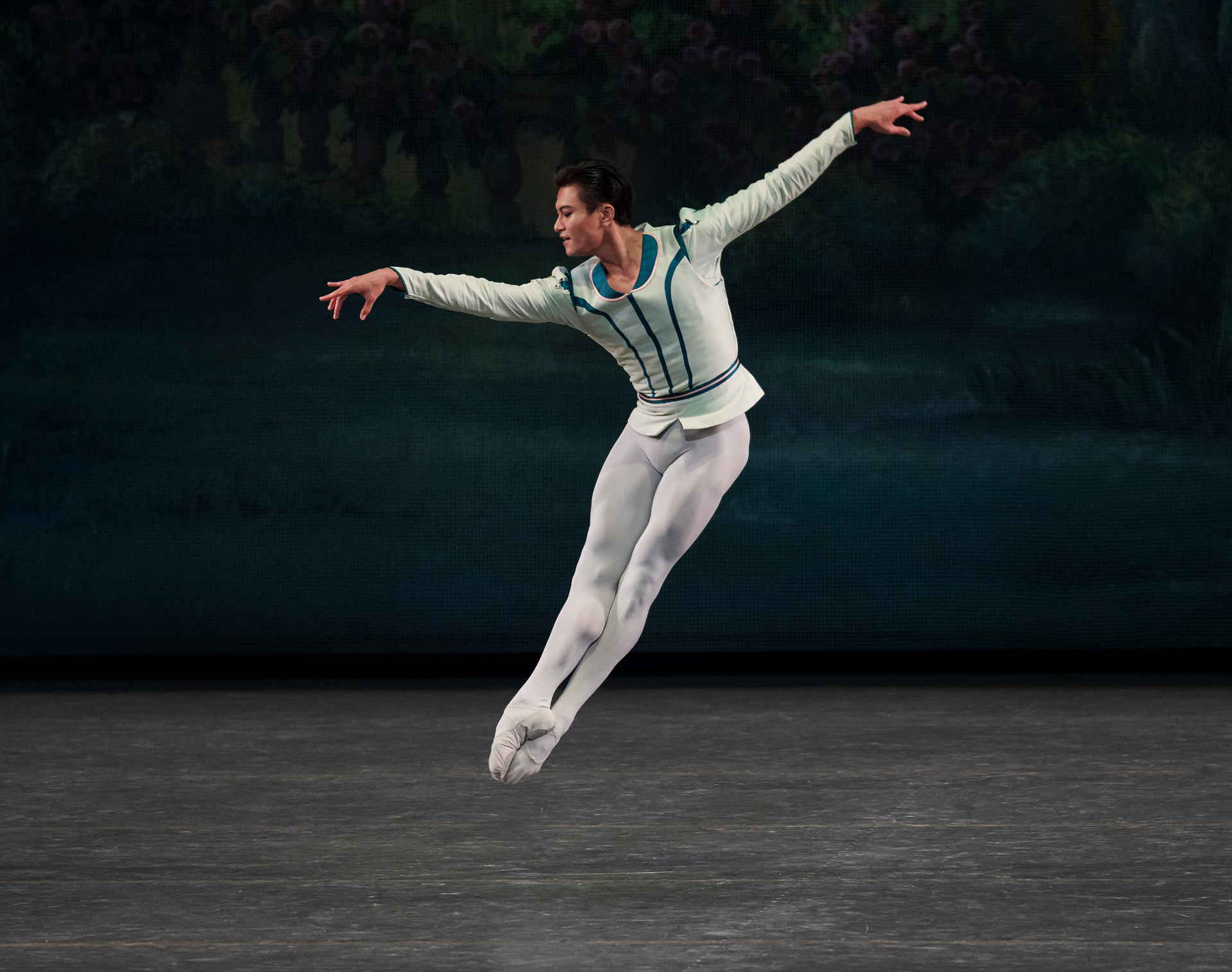 Raymonda Variations series — Raymonda Variations — soaring solo leap with extended arabesque arms in pale blue tunic against painted garden backdrop